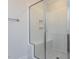 Modern bathroom featuring glass enclosed shower with bench, white tile, and neutral floor, offering a sleek design at 6048 Scalybark Rd, Durham, NC 27712
