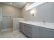 Double vanity bathroom with grey cabinets, quartz countertops, and marble flooring at 6048 Scalybark Rd, Durham, NC 27712