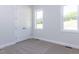 Neutral bedroom featuring a closet and two windows for ample natural light at 6048 Scalybark Rd, Durham, NC 27712