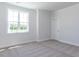 Bright bedroom features neutral carpet, a single window, decorative trim, and a doorway, offering a serene and inviting space at 6048 Scalybark Rd, Durham, NC 27712