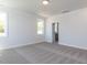 Bright bedroom featuring plush carpet, neutral walls, large windows and a doorway that adds depth to the space at 6048 Scalybark Rd, Durham, NC 27712