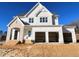 Two-story house with white siding, three-car garage, and a partially landscaped yard at 6048 Scalybark Rd, Durham, NC 27712