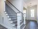 Inviting foyer with hardwood floors, staircase, and a modern chandelier at 6048 Scalybark Rd, Durham, NC 27712