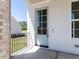 The covered front porch features a light blue front door and a wrought iron railing at 6048 Scalybark Rd, Durham, NC 27712