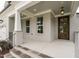 Inviting front porch with brick columns and a wooden door at 6048 Scalybark Rd, Durham, NC 27712