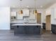Modern kitchen featuring a large island, pendant lighting, and stainless steel appliances at 6048 Scalybark Rd, Durham, NC 27712