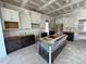 Unfinished kitchen with dark island and white cabinets, showing layout and design at 6048 Scalybark Rd, Durham, NC 27712