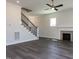 Cozy living room features a fireplace, hardwood floors, staircase, and ceiling fan at 6048 Scalybark Rd, Durham, NC 27712