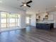Open-concept living room features hardwood floors, a kitchen island, and access to a porch at 6048 Scalybark Rd, Durham, NC 27712
