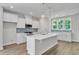 Island kitchen with white cabinetry, pendant lighting, stainless appliances, and blue backsplash provides modern elegance at 9140 Dupree Meadow Dr # 9, Angier, NC 27501