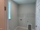 Neutral colored laundry room includes window, laundry hookups, and storage shelves at 9140 Dupree Meadow Dr # 9, Angier, NC 27501