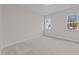 An empty bedroom with wall-to-wall carpeting, two windows, and neutral paint at 820 Willow Tower Ct # 153, Rolesville, NC 27571