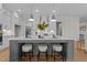 Beautiful kitchen island with white countertops, pendant lighting, and seating for three people at 820 Willow Tower Ct # 153, Rolesville, NC 27571
