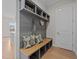 Mudroom with gray wood paneled wall, bench with cushions and storage, and overhead shelving at 820 Willow Tower Ct # 153, Rolesville, NC 27571