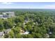 An aerial view showcases houses nestled among trees with a skyline in the background at 4123 Rockingham Dr, Raleigh, NC 27609