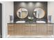 Modern bathroom with double sink vanity, round mirrors, and neutral color palette at 4123 Rockingham Dr, Raleigh, NC 27609