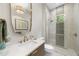 Modern bathroom with gold fixtures, a glass-enclosed shower, and decorative mirror at 4123 Rockingham Dr, Raleigh, NC 27609