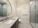 Modern bathroom featuring a glass shower and a large round mirror above the sink at 4123 Rockingham Dr, Raleigh, NC 27609