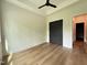 Spacious bedroom with a ceiling fan, hardwood floors, and dark colored closet doors at 4123 Rockingham Dr, Raleigh, NC 27609