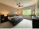 Modern bedroom with sleek furniture, ceiling fan, and a large window overlooking greenery at 4123 Rockingham Dr, Raleigh, NC 27609
