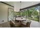 Covered deck with dining area and outdoor living space overlooking trees at 4123 Rockingham Dr, Raleigh, NC 27609