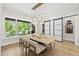 Bright dining room boasts a modern light fixture, sliding doors, and a large window with backyard views at 4123 Rockingham Dr, Raleigh, NC 27609