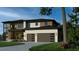 Contemporary home with a combination of wood and stone accents, featuring a multi-car garage and a beautifully landscaped front yard at 4123 Rockingham Dr, Raleigh, NC 27609