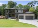 Modern two story home boasts a manicured lawn, two car garage, and stone and wood exterior at 4123 Rockingham Dr, Raleigh, NC 27609