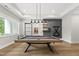 Billiard room with modern pool table, accent wall, decorative shelving, and abundant light at 4123 Rockingham Dr, Raleigh, NC 27609