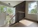 Modern hallway with a staircase featuring large windows offering beautiful outdoor views at 4123 Rockingham Dr, Raleigh, NC 27609