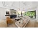 Spacious living room featuring a modern fireplace, coffered ceiling, and access to the outdoors at 4123 Rockingham Dr, Raleigh, NC 27609