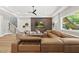 Open-concept living area with hardwood floors, a textured accent wall, and a large, cozy sectional sofa at 4123 Rockingham Dr, Raleigh, NC 27609