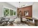 Bright home office with a large window, wooden desk, and comfortable seating area at 4123 Rockingham Dr, Raleigh, NC 27609