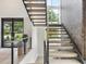 Modern staircase with wooden steps, metal railings, and large windows at 4123 Rockingham Dr, Raleigh, NC 27609