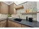 Close-up of the wet bar with stone backsplash, wood cabinetry, and stainless steel fixtures at 4123 Rockingham Dr, Raleigh, NC 27609
