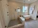 Modern bathroom with a soaking tub, glass shower, and neutral tile at 165 Inspiration Way, Fuquay Varina, NC 27526