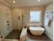 Modern bathroom with a soaking tub, glass shower, and neutral tile at 165 Inspiration Way, Fuquay Varina, NC 27526