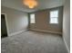 Bright bedroom featuring plush gray carpeting, two windows, and fresh neutral paint at 165 Inspiration Way, Fuquay Varina, NC 27526