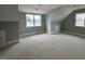 A large bonus room with two windows, neutral walls and flooring, perfect for customization at 165 Inspiration Way, Fuquay Varina, NC 27526