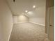 Spacious bonus room featuring plush gray carpeting, ample natural light, and fresh neutral paint at 165 Inspiration Way, Fuquay Varina, NC 27526