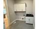 Functional laundry room offers utility sink and storage cabinets at 165 Inspiration Way, Fuquay Varina, NC 27526