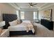 Bright, spacious main bedroom featuring plush carpeting, a ceiling fan, and several windows at 165 Inspiration Way, Fuquay Varina, NC 27526