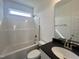 Clean and modern bathroom featuring sleek vanity with black countertop and a shower-tub combination at 189 Waterwheel Dr, Selma, NC 27576