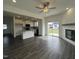 Open living room flowing into a kitchen featuring a fireplace, large windows and hardwood floor at 189 Waterwheel Dr, Selma, NC 27576