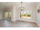 Bright dining area features modern flooring, neutral paint, a contemporary chandelier, and sliding glass doors at 35 Uptown Rd, Zebulon, NC 27597
