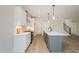 Stylish kitchen showcasing white cabinetry, a gray island with a sink, and stainless steel appliances at 35 Uptown Rd, Zebulon, NC 27597