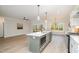 Modern kitchen featuring a large island, stainless steel appliances, and a seamless flow into the living area at 35 Uptown Rd, Zebulon, NC 27597