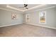 Spacious bedroom with tray ceilings, recessed lighting, and large windows providing natural light at 35 Uptown Rd, Zebulon, NC 27597