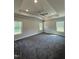 Large main bedroom features a tray ceiling, fan, and three windows at 60 Lemon Drop Ln, Franklinton, NC 27525