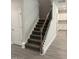 Carpeted staircase features modern wood and black iron railing leading to upper level at 60 Lemon Drop Ln, Franklinton, NC 27525